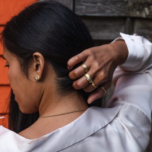 FLOW earrings and rings in sustainable and ethical 18k Fairmined ECO Gold on model by Dorothee Rosen