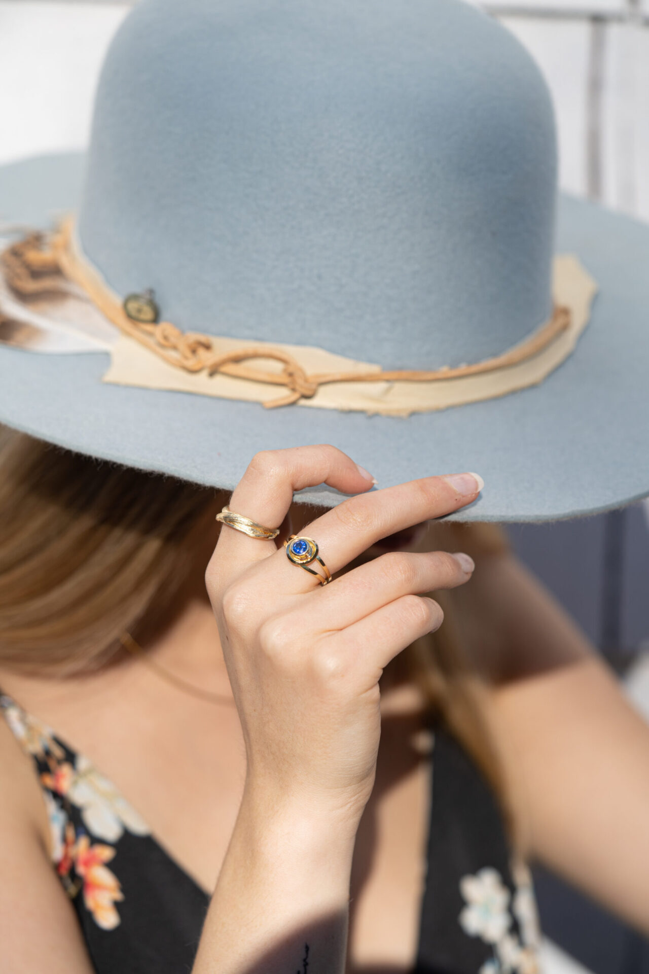 Dorothee Rosen 18k Yellow Gold ring with sapphire and 100% Fairmined Eco gold ring with hat in hand on model