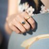 Dorothee Rosen 18k Yellow Gold ring with sapphire and 100% Fairmined Eco gold ring with hat in hand on model